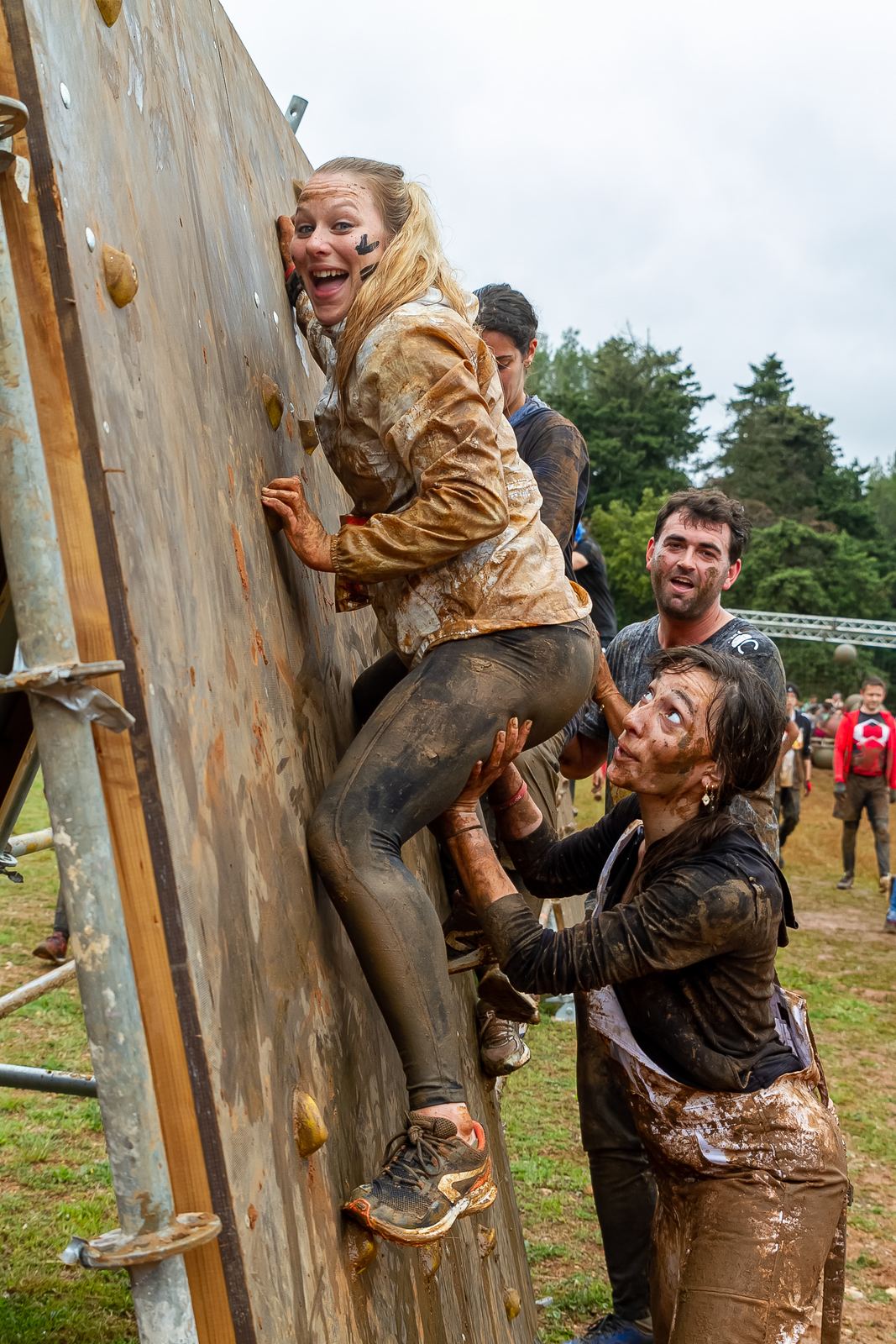 Participants s'entraidant sur un obstacle